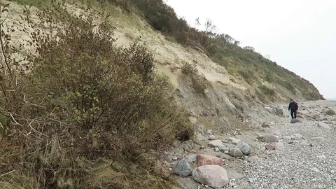 Man walking along beach of Hiddensee isle (Germany) searching fossils. Video stock 69801524