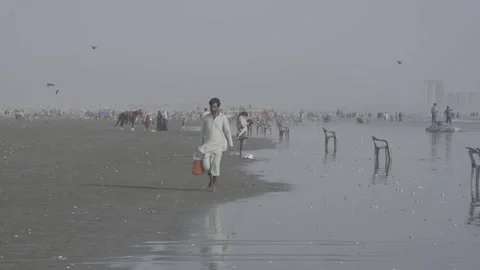 A man walking along the beach in Karachi, Pakistan Stock Footage 343875567