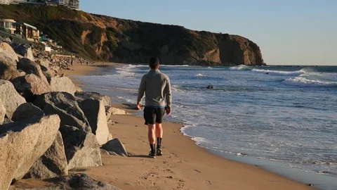 Man is walking along beach near ocean. Stock-Footage 102171663