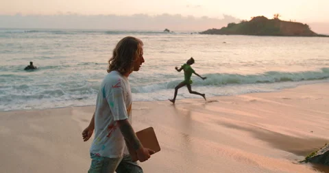 A man is walking along the beach with a tablet in his hands Stock Footage 105734550
