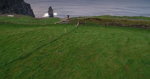 Man walking along the Cliffs of Moher Stock Footage 58647997