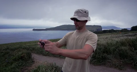 A man walking along the coast and taking selfie. Vladivostok, Pacific. Steadycam Stock Footage 100769815