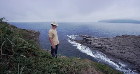 A man walking along the coast. View of steep cliffs. Asia, far East, Pacific Stock Footage 100767208