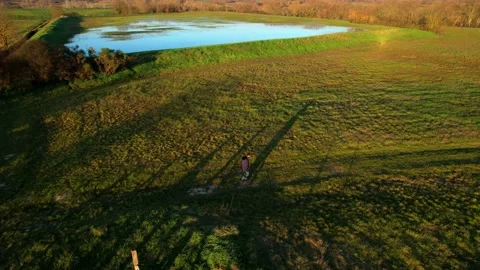 Man walking along field path alone Aerial Italy drone gymbal orbit  Stock Footage 232317038