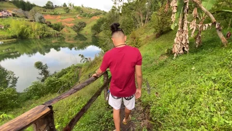 Man walking along a path to a lake. Hostel experiences Stock Footage 230978719