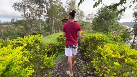 Man walking along a path through bushes at dawn Stock Footage 230978527