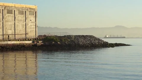 Man walking along pier during sunrise San Francisco Bay Stock Footage 233902854