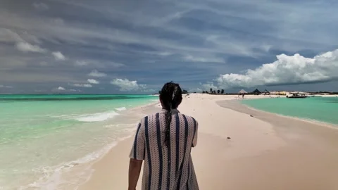 Man walking along a pristine sandbar in Los Roques Venezuela for a peaceful Vidéo 345650975