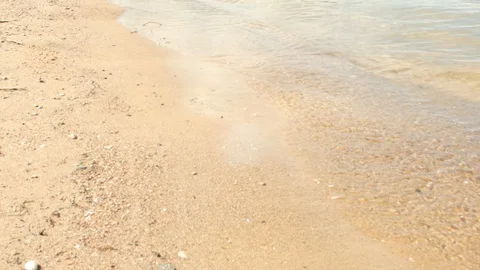A man is walking along a sandy beach along the sea. 4K Stock Footage 86581689
