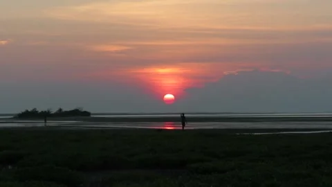 Man walking along a shallow beach in red sunset Mannar Sri Lanka Stock Footage 162149439
