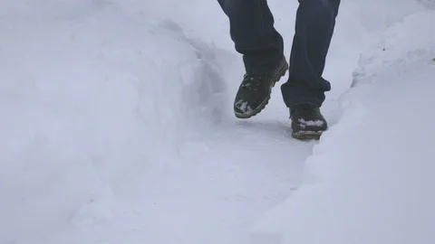 A man is walking along a snow path. A lot of snow, hard frost. Video stock 102331820
