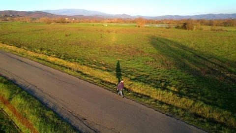 Man walking along street field alone Stock Video Pond5