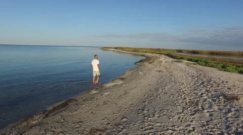 Man is walking along the wild beach Stock-Footage 68323843