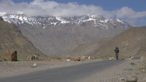 A man walking among the mountains Stock Footage 141787960