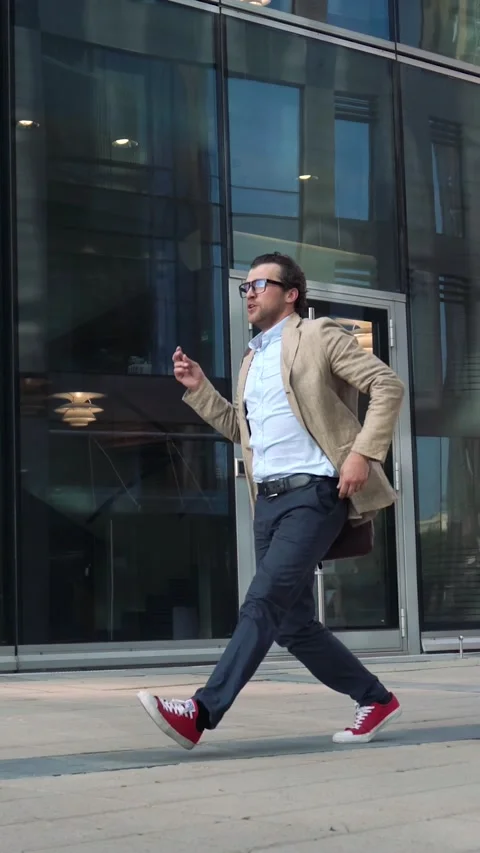 Man walking and dancing near modern glass building Video stock 224443365