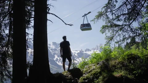 Man walking up and looking at a mountain cable car, nice view Stock Footage 166630594