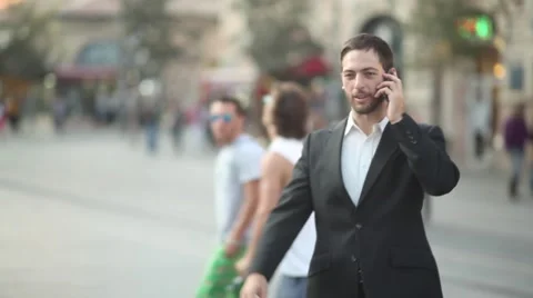 Man walking and talking in Iphone [shallow depth of field] Stock Footage 42254399