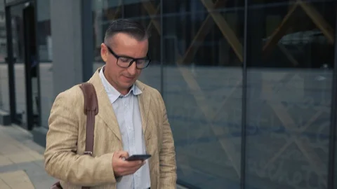 Man walking and using smartphone Stock Footage 92088974