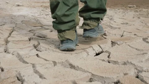 Man walking on arid remote ground Video stock 131664622