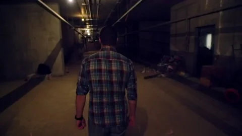 Man walking away from the camera in a basement Video stock 132355943
