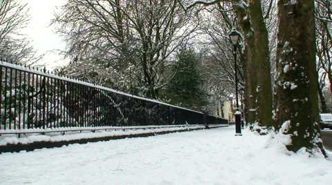 Man walking away from camera in snow covered street Stock Footage 1057441