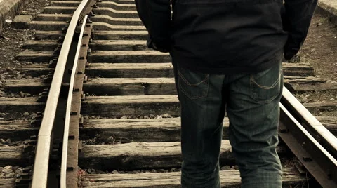 Man walking away in the middle of the rail tracks Stock Footage 54112751