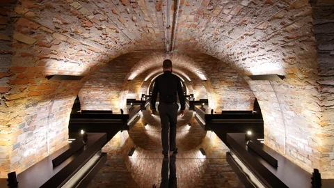 Man walking back on glass ground, stone wall. very cinematic shot for business, Stock Footage 124991973
