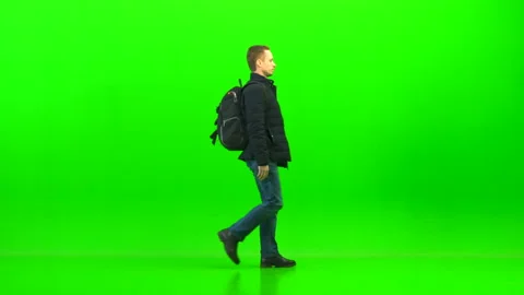 The man walking with a backpack on the green background Vídeos de archivo 91112028