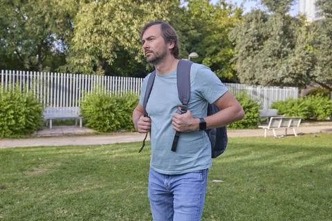 Man Walking with Backpack in Green Park Stock Photos