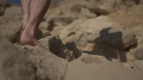 Man walking bare feet on sand with rocks. Real life urban escape concept Stock Footage 100175328