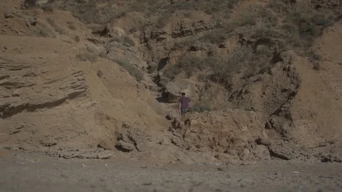 Man walking bare feet on sand with rocks. Real life urban escape concept Stock Footage 100175397