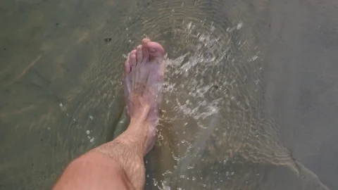Man Walking Bare Foot On Sandy Beach Into Ocean Water Video stock 77231198
