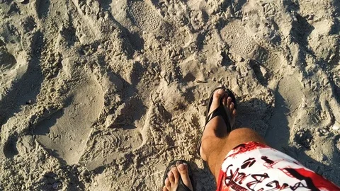 Man walking bare foot on sandy beach Stock Footage 112753700