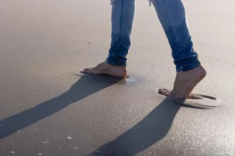 Man walking barefoot on the beach Stock Photos