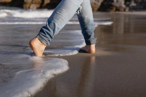 Man walking barefoot on the beach Stock Photos