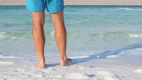 Man walking barefoot on Dead Sea salt beach Jordan wellness travel concept .. Stock-Footage 330040045