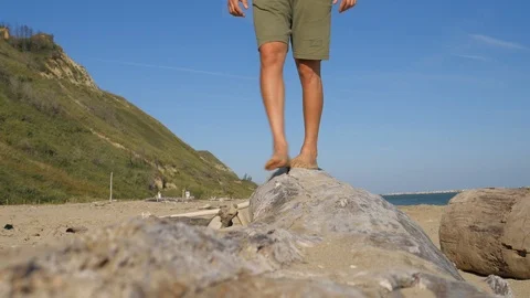 Man walking barefoot on fallen tree trunk on beach . relaxing in nature, enjoy Stock Footage 117135257