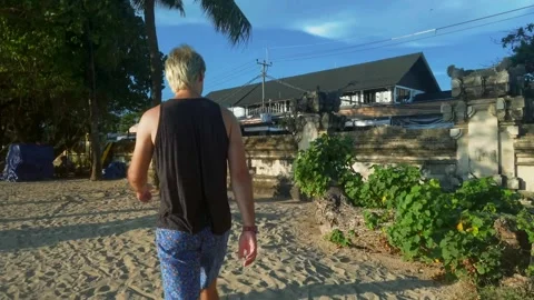 Man walking on the beach between trees Stock Footage 153732616