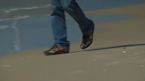 Man walking on beach closeup to legs Stock Footage 25179045