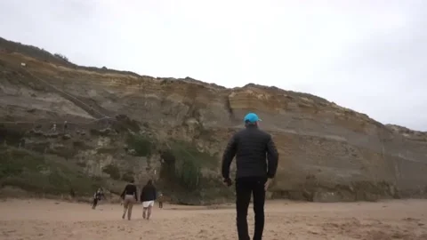 Man Walking on a Beach on a Cloudy Day Stock Footage 231590061