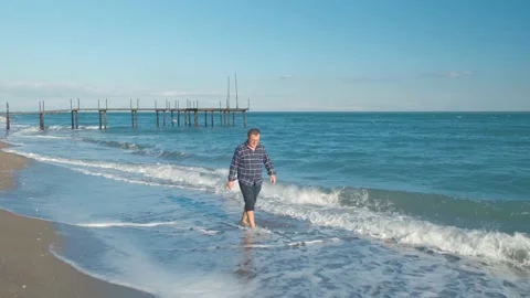 Man walking on the beach Stock Footage 168297318