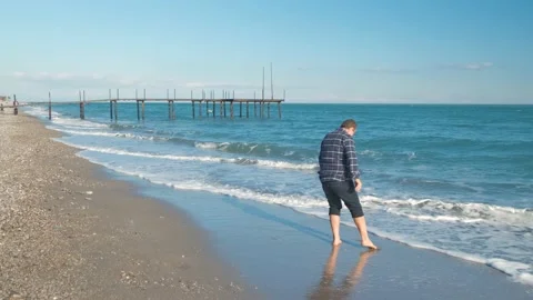 Man walking on the beach Stock Footage 168297602