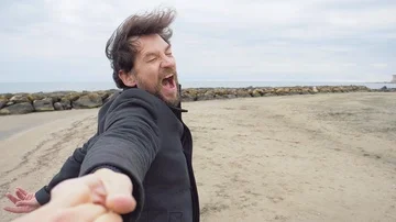 Man walking on beach holding hand of girlfriend saying I love you slow motion Stock Footage 85528843
