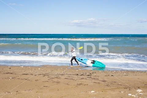 Man walking on the beach with kayak. Traveling by sea. Leisure activities on the Stock Photos