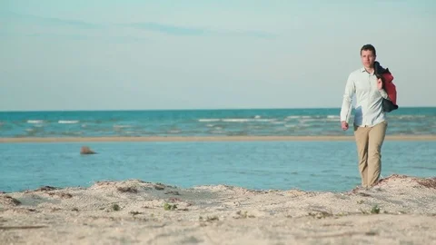 Man walking beach with laptop at hand Video stock 76202254