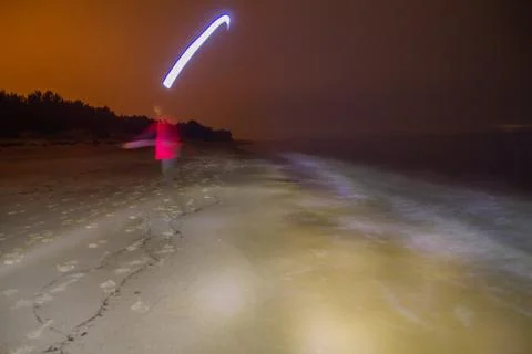 Man walking on the beach at night Stock Photos