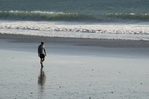 A man walking on the beach Stock Photos