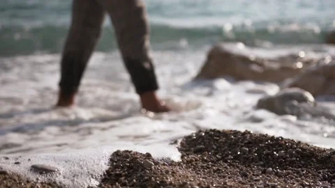 Man walking on the beach. Sea waves touching his feet Stock Footage 147555399