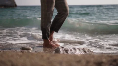 Man walking on the beach. Sea waves touching his feet Stock Footage 147555412