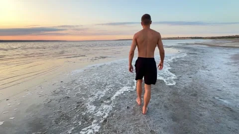 Man Walking on Beach Shore at Golden Hour Sunset Stock Footage 342135355